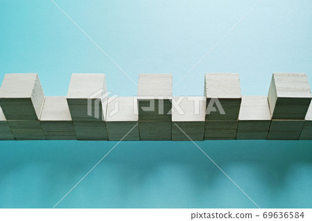 Wooden cubes that are lined up side by side without any gaps and lined up with a gap of one on top. Wooden cubes that are lined up side by side without any gaps and lined up with a gap of one on top. 69636584