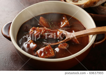 Beef stew on a reddish brown background Beef stew on a reddish brown background 69637993