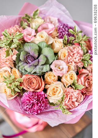 Beautiful spring bouquet on wooden table.. Arrangement with various flowers. The concept of a flower shop. A set of photos for a site or catalogue. Work florist. Beautiful spring bouquet on wooden table.. Arrangement with various flowers. The concept of a flower shop. A set of photos for a site or catalogue. Work florist. 69638208