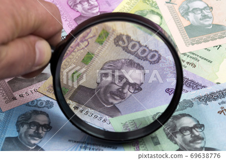 Currency of Bangladesh in a magnifying glass a business background Currency of Bangladesh in a magnifying glass a business background 69638776