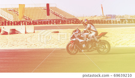 motorcycle racer rides on a sports track 69639210