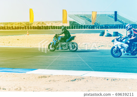 motorcycle racer rides on a sports track 69639211