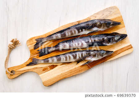 Top view of fresh icefish on wooden cutting board Top view of fresh icefish on wooden cutting board 69639370