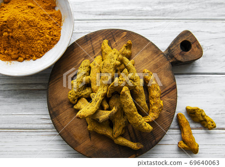 Turmeric powder and dry roots 69640063