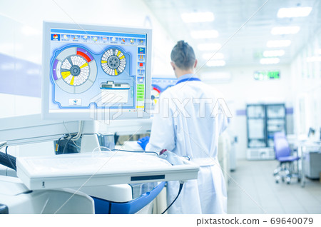 Laboratory assistant in rubber gloves working with a modern immunochemistry analyzer Laboratory assistant in rubber gloves working with a modern immunochemistry analyzer 69640079