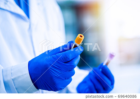 Hands in rubber gloves hold test tubes. Hands in rubber gloves hold test tubes. 69640086