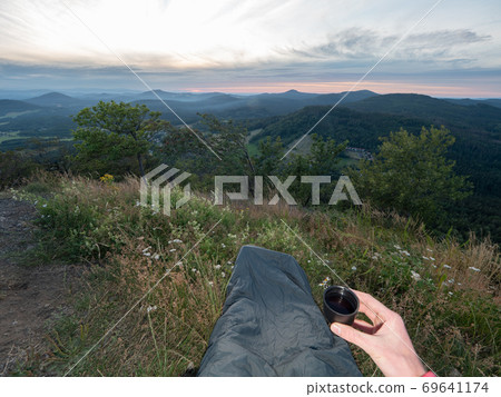 Morning cup of tea after bivouac sleeping on mountain 69641174