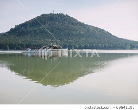 Passengers boat pass the bay and continue in lake tour. 69641193