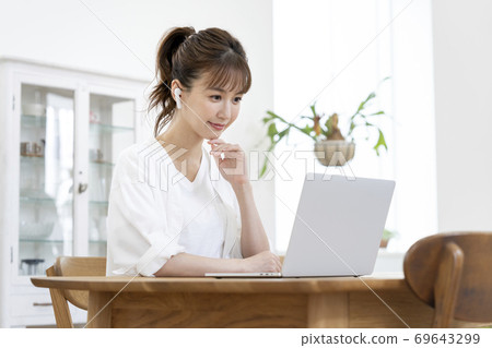 A young woman heading for a laptop 69643299