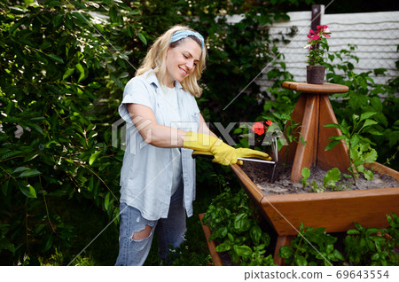 Woman with hoe at the flowerbed in the garden 69643554