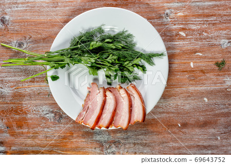 smoked meat lies on the table with herbs and sauce smoked meat lies on the table with herbs and sauce 69643752
