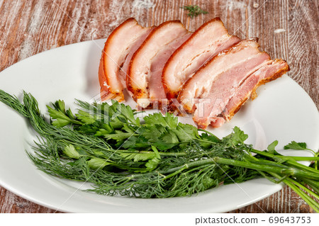 smoked meat lies on the table with herbs and sauce smoked meat lies on the table with herbs and sauce 69643753