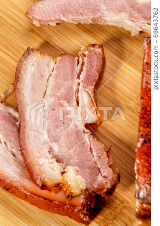 smoked meat cut into slices lies on a wooden table smoked meat cut into slices lies on a wooden table 69643762
