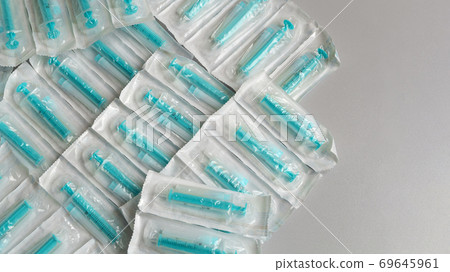 Medical syringes in a package. A bunch of unused, packaged syringes. 69645961
