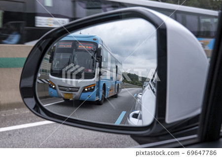 通過後視鏡可以看到在專用車道上行駛的公交車 通過後視鏡可以看到在專用車道上行駛的公交車 69647786