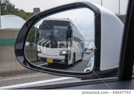 A bus running on a dedicated lane viewed through a side mirror A bus running on a dedicated lane viewed through a side mirror 69647793