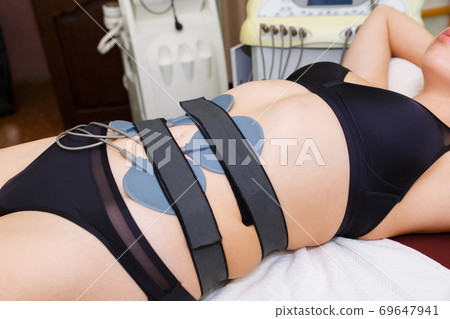 Modern muscle myostimulation in the massage room. Modern muscle myostimulation in the massage room. 69647941