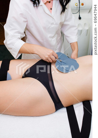 Anti-cellulite massage on the thighs with myostimulation. Anti-cellulite massage on the thighs with myostimulation. 69647944