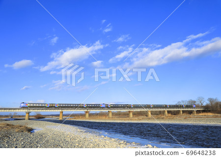 [Nemuro Main Line Kiha 283] Limited Express Super Ozora crossing the Satsunai River under the blue sky 69648238