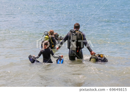 divers enter the water on the beach 69649815