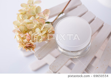 white cosmetics container and hydrangea inflorescence on a white background. Health, body care 69650554