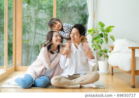 一家三口，一個女孩和一個媽媽的肖像，piggy帶在客廳的地板上 69650717