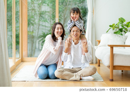 一家三口，一個女孩和一個媽媽的肖像，piggy帶在客廳的地板上 69650718