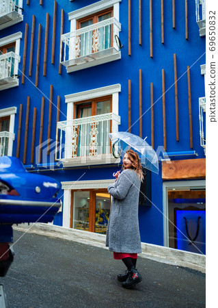 light brown hair girl blue wall under umbrella 69650832