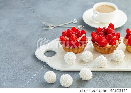 Fruit dessert tarts with cream and strawberry on stone table Fruit dessert tarts with cream and strawberry on stone table 69653111