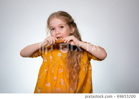 The little girl eating the pizza and laughing. 69653200