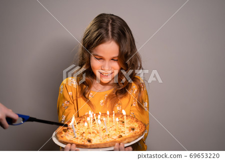 a teen pizza with candles, lighter lights candles 69653220