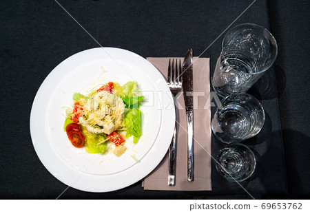 white plate with salad, fork and knife, glasses white plate with salad, fork and knife, glasses 69653762