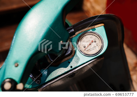 a speedometer on a turquoise retro moped 69653777
