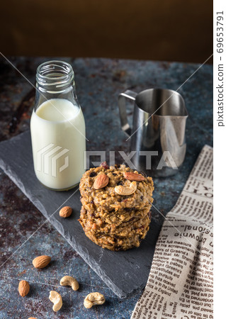 Oatmeal cookies with milk on table. Chocolate chip cookies with milk. Oatmeal cookies with milk on table. Chocolate chip cookies with milk. 69653791