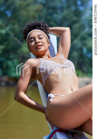 Asian model in bikini posing with old fishing boat Asian model in bikini posing with old fishing boat 69653946