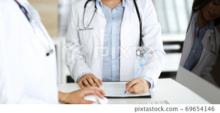 Unknown woman-doctor controls medication history record and medical exam results, close-up. Medicine concept Unknown woman-doctor controls medication history record and medical exam results, close-up. Medicine concept 69654146