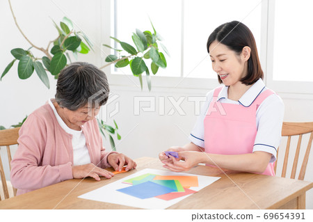 Caregiver rehabilitating seniors together Caregiver rehabilitating seniors together 69654391