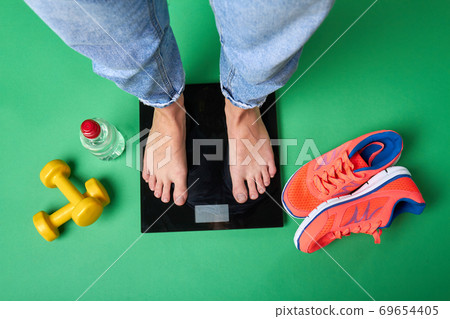 Sportsman's standing on bathroom scales. 69654405