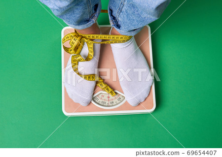 Close-up feet with socks standing on scales. 69654407