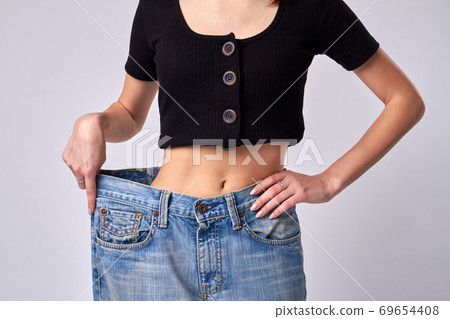 Slim girl shows off weight loss progress. 69654408