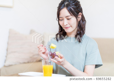 Woman eating fruit and relaxing 69655282