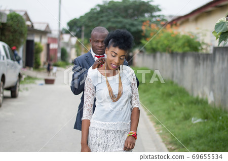 Young man in a suit wearing a chain to his wife Young man in a suit wearing a chain to his wife 69655534