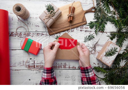 Girls hands on red shirt hold an envelope with red paper on white background Girls hands on red shirt hold an envelope with red paper on white background 69656056