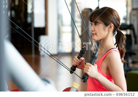 A woman doing muscle training at a gym A woman doing muscle training at a gym 69656152