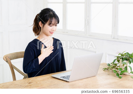 Young woman putting hands on chest Young woman putting hands on chest 69656335