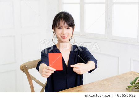 Young woman holding a red card in her hand Young woman holding a red card in her hand 69656652