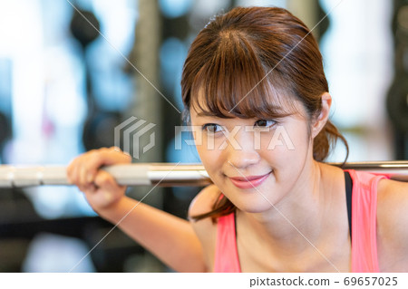 一個女人在體育健身房鍛煉肌肉 69657025