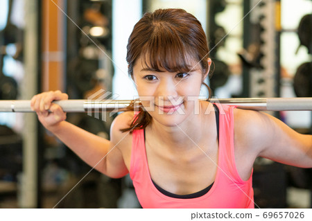 一個女人在體育健身房鍛煉肌肉 69657026