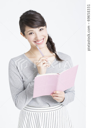 Woman writing a schedule Woman writing a schedule 69658331
