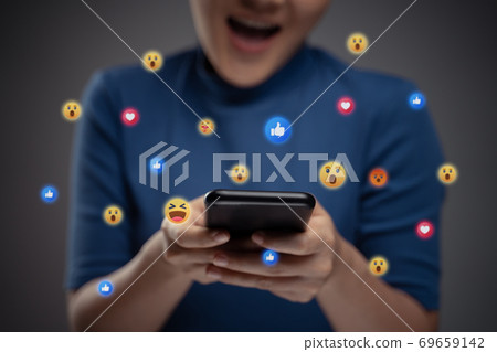 Asian woman using smart phone for social media with emoticon bubble. 69659142